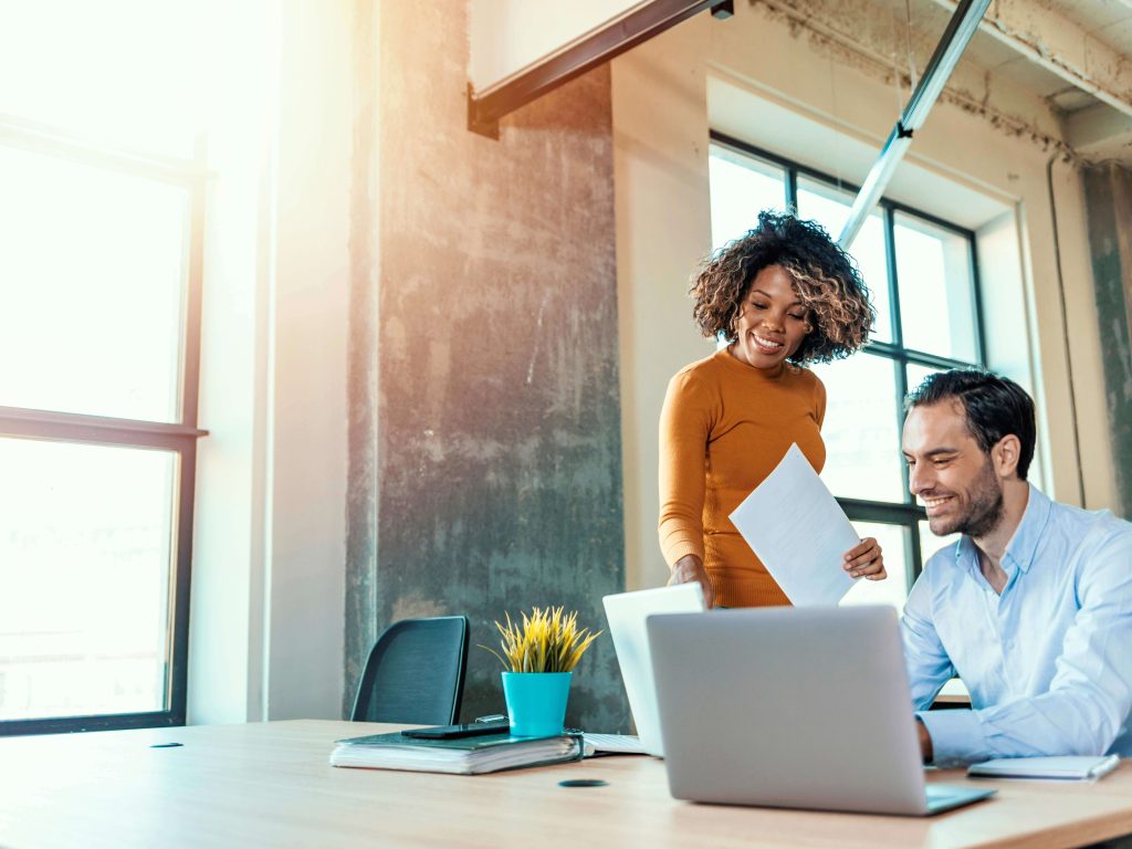 women looking at computer screen male colleague