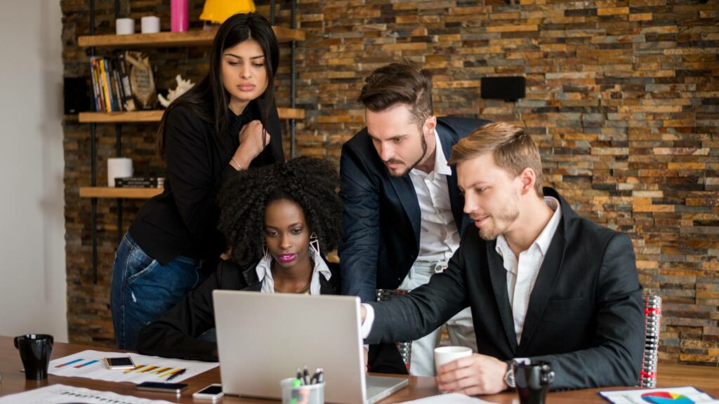 People of different ethnicities looking at a computer